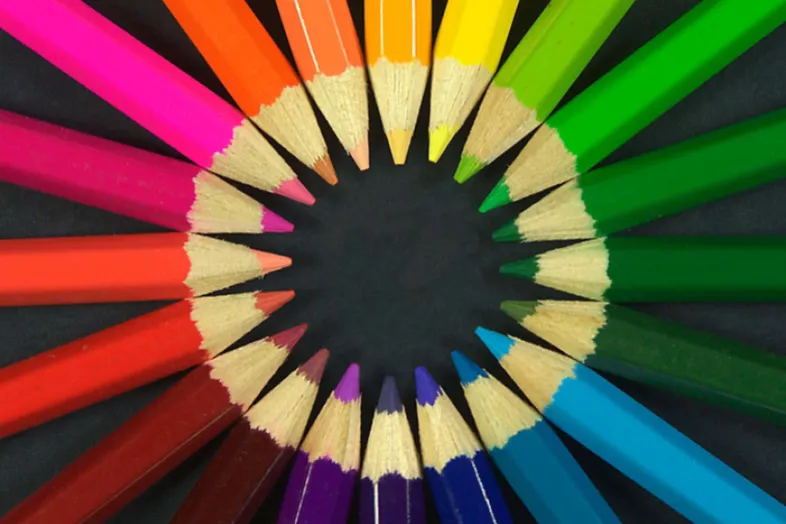 Photographie de crayons de couleurs disposés en rond avec la mine pointant vers l'intéreieur.